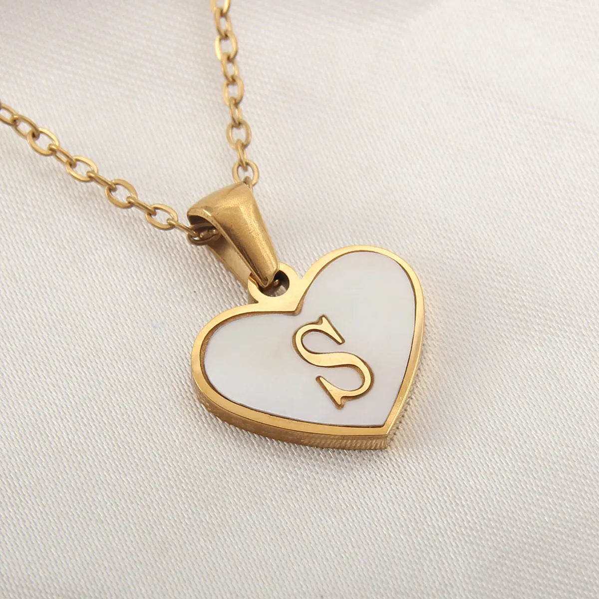 Gold heart necklace with white shell detail and personalised initial letter on adjustable chain