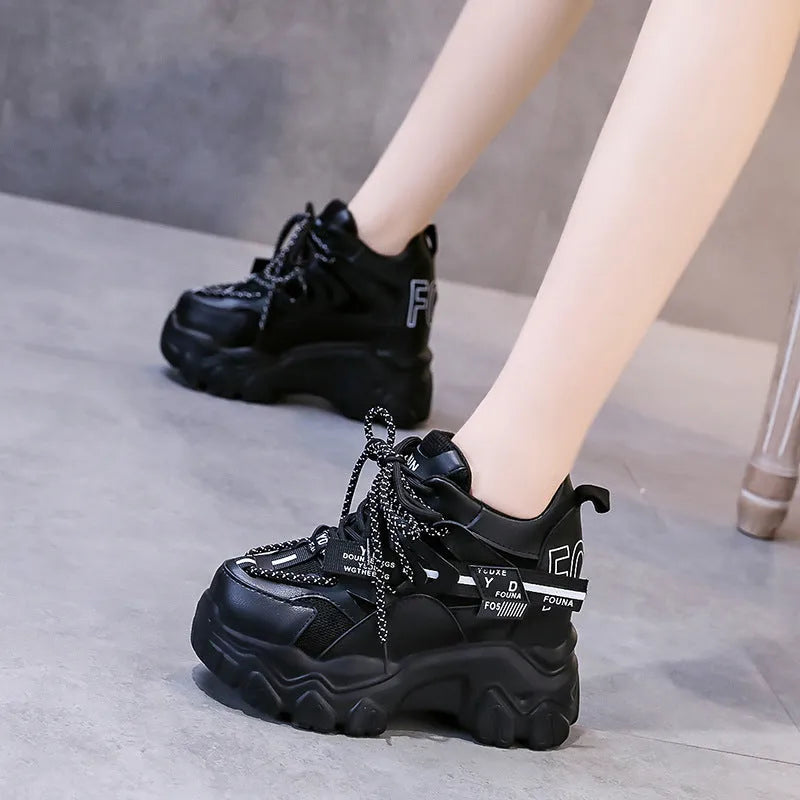 Women's white and black mesh platform tennis shoes with cross strap and thick rubber sole.