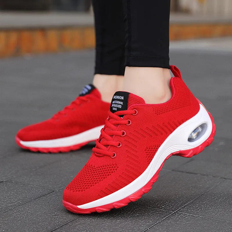 Women's black mesh sneakers with front lace-up and round toe, showing mid-heel profile