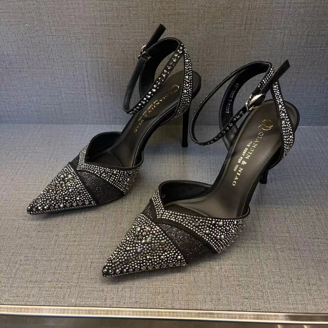 Women's silver high heels with hollow cut-out design and red stiletto heel sole.