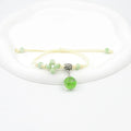 Glass bracelet with large colourful beads containing real dried flowers, on a white background.