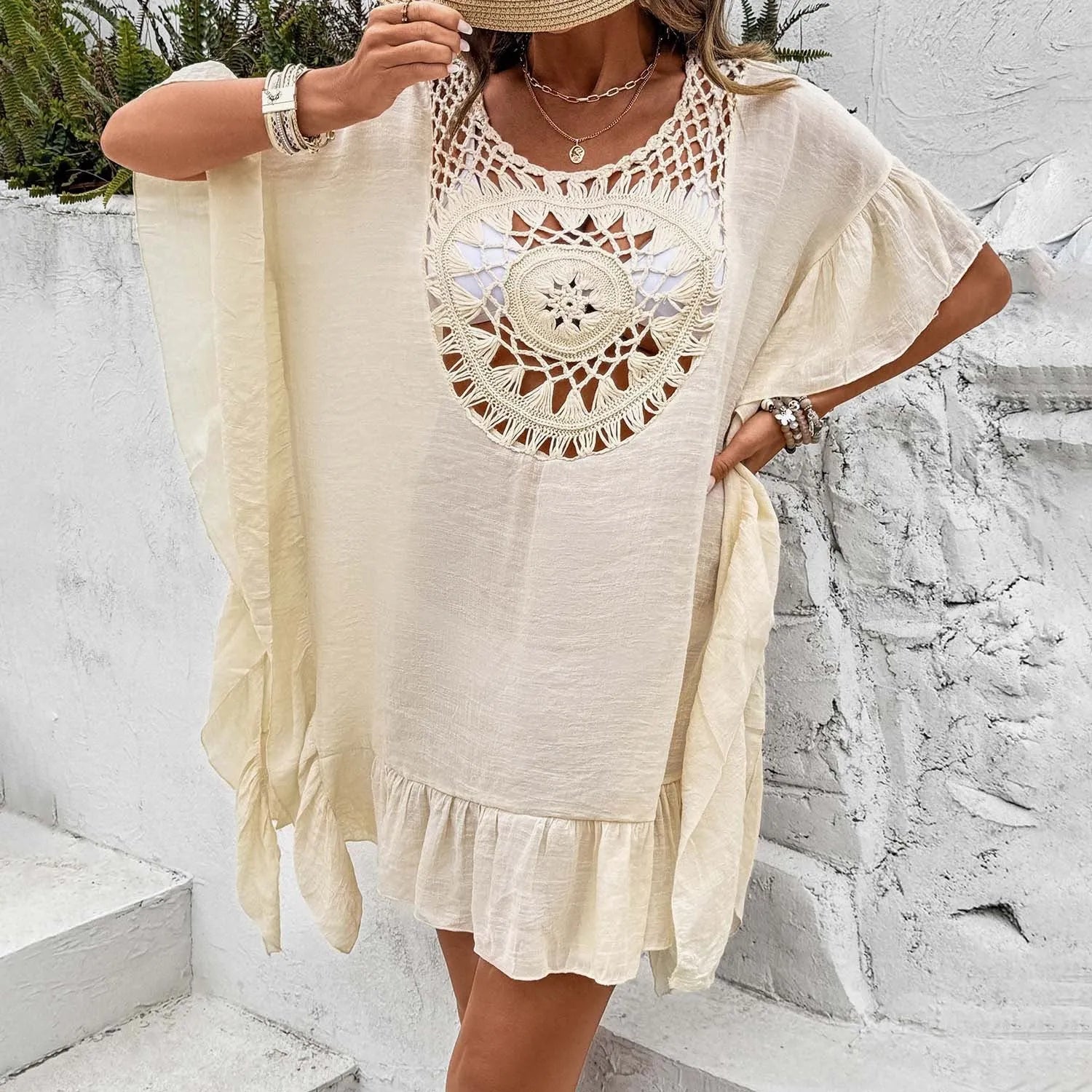 Crochet tassel detail on a patchwork skirt-style beach cover-up dress in apricot colour.