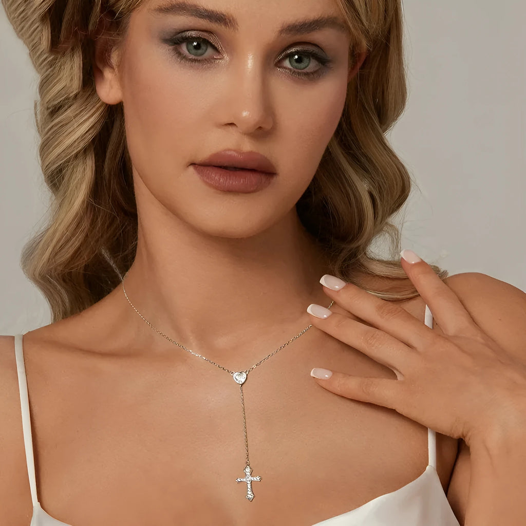 Close-up of a delicate silver love cross pendant on a thin O-ring chain, designed for V-neck wear.