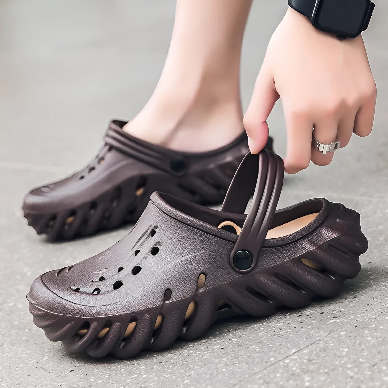 Men's beige EVA slipper sandals with hollow-out design and round toe holder on a plain background.