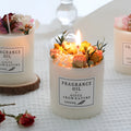Decorative dried flower scented candle in gift box with wooden base, showing embedded botanicals.