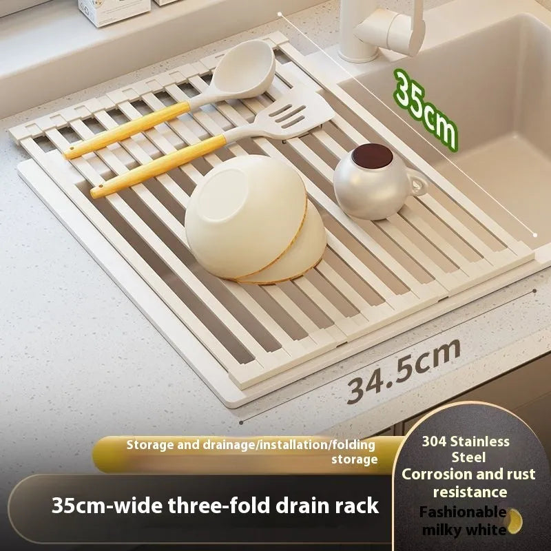 A milky white foldable stainless steel kitchen draining rack shown open on a countertop next to a sink.