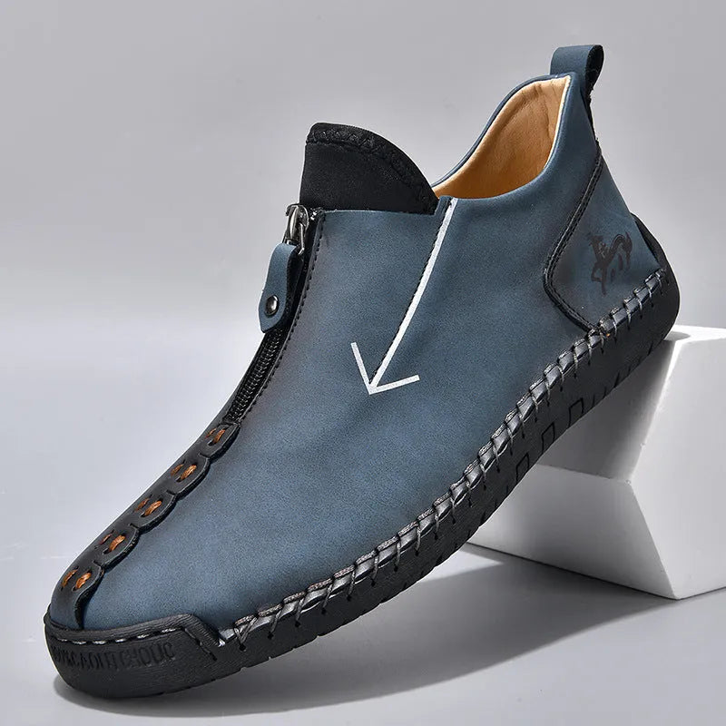 Men's brown leather boots with front zip closure and hand-stitched rubber soles