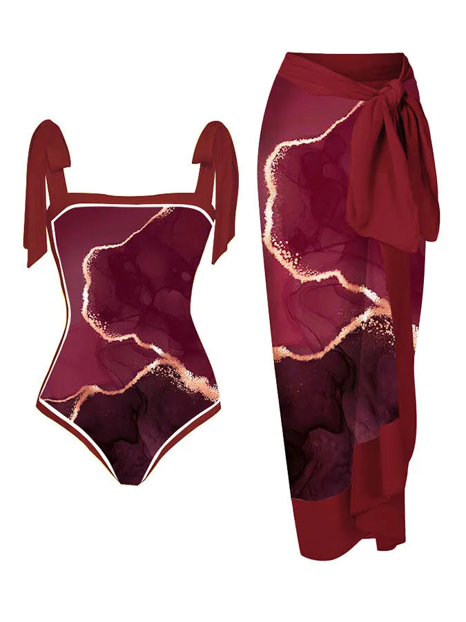Women's floral print two-piece swimsuit with a blue chiffon skirt laid flat.