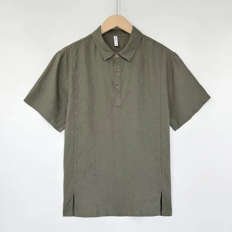 Man wearing a loose grey green linen short sleeve shirt with thin lapels.
