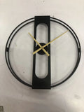 Round metal wall clock with 50cm diameter in black or gold colour on a wall.
