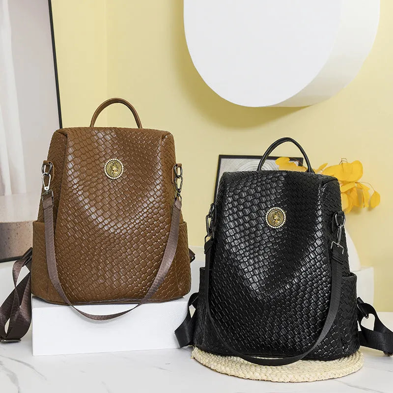 Women's black anti-theft backpack with weaving stitching detail and multiple internal compartments
