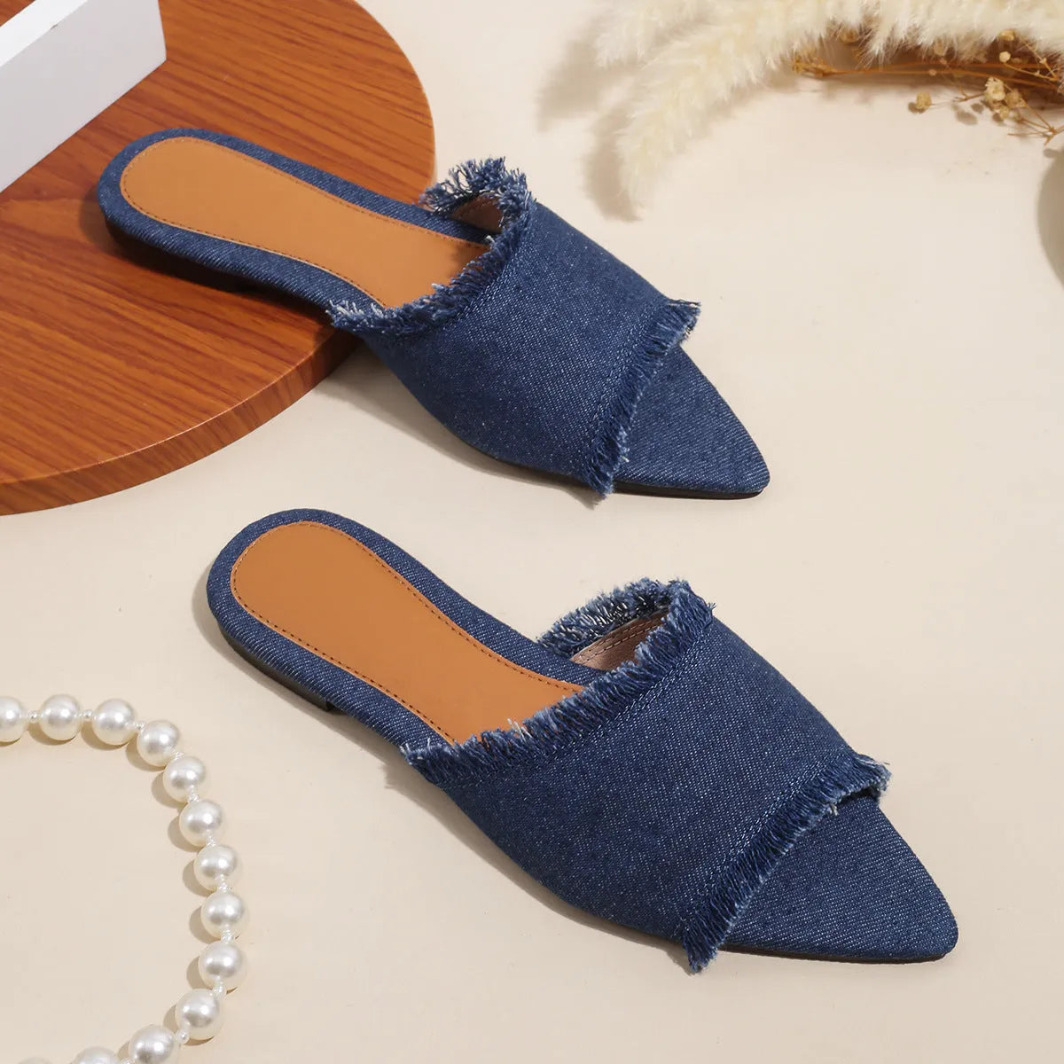 Women's casual denim flat slippers with leather lining and tassel detail.