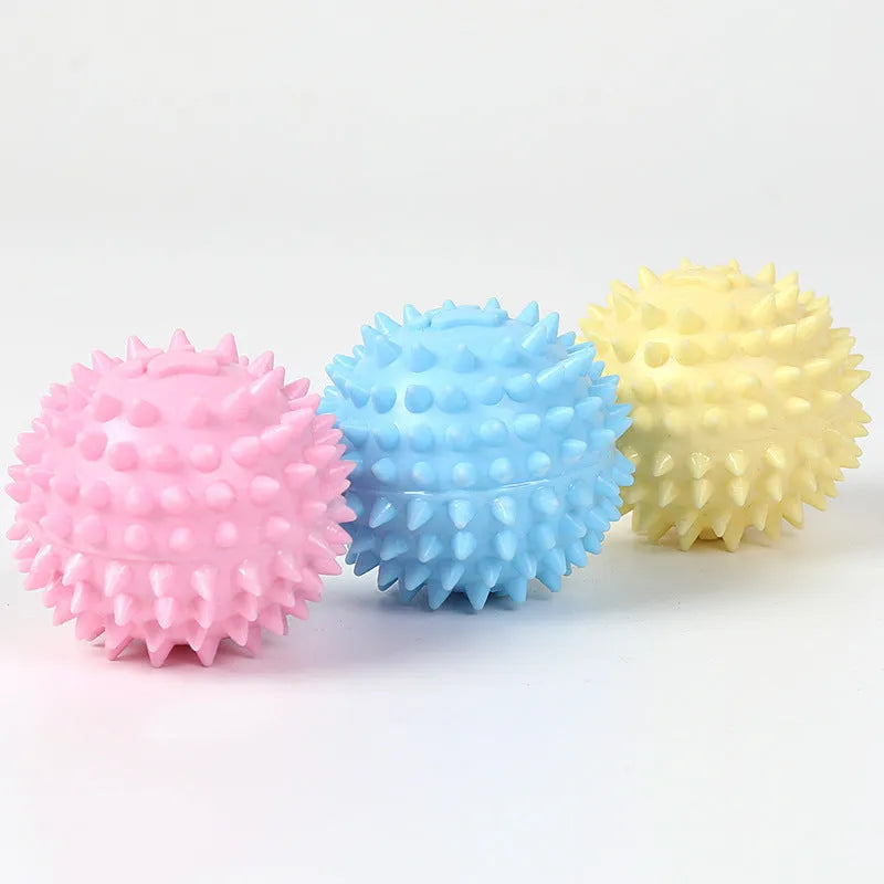 Blue, pink, or yellow TPR dog chewing ball with textured sides for tooth cleaning