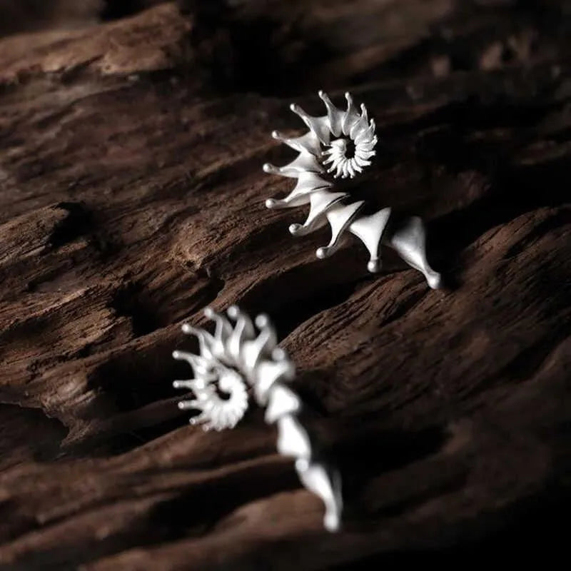 A pair of matte finish conch stud earrings with an exaggerated three-dimensional and irregular design.