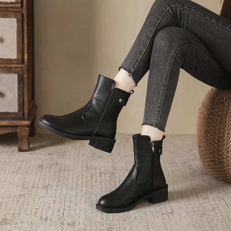 Black women's short ankle boots with a side zip, low heel, and round toe on a rubber sole.