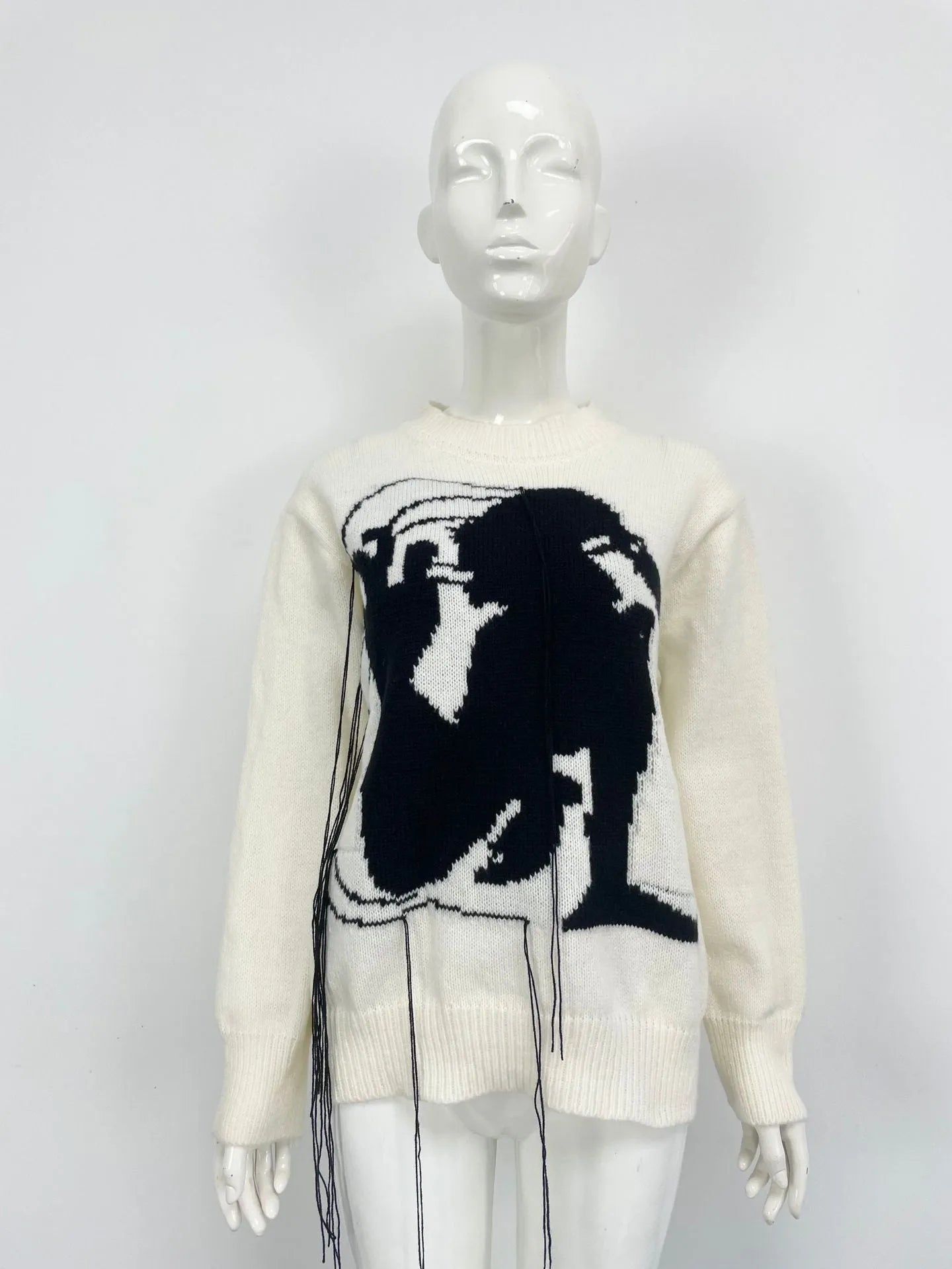 Grey alpaca wool women's sweater with abstract pattern and tassel detail on sleeve.