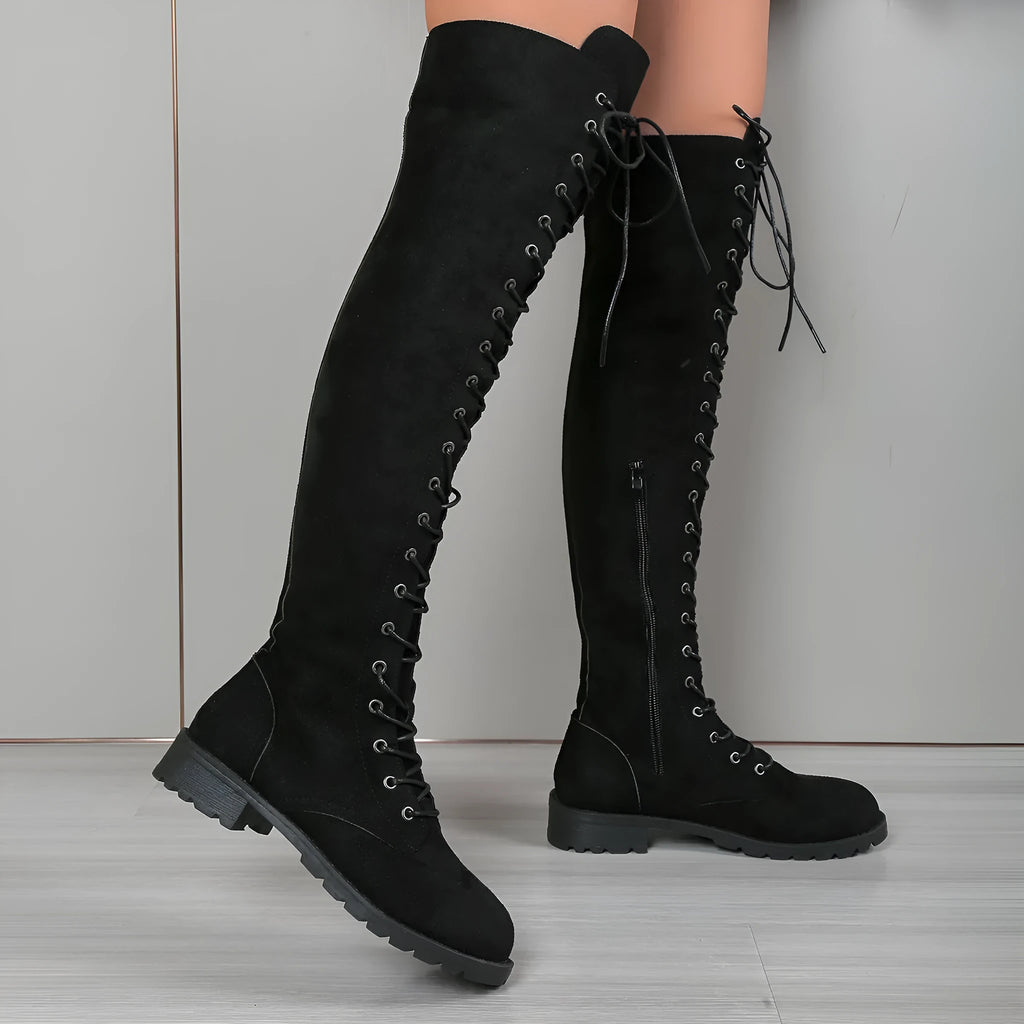 Women's black lace-up over-the-knee boots with round toe and flat rubber sole on a neutral background.