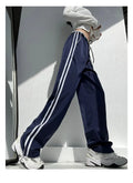 Women's navy blue loose straight-leg trousers with thin fabric and ribbon parallel bars contrast detail.
