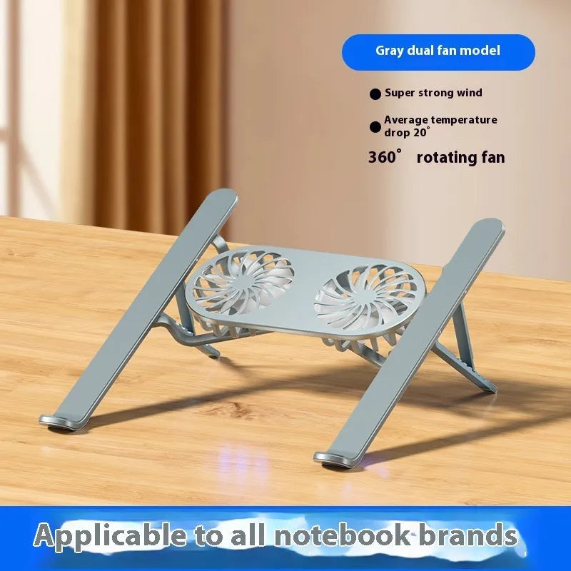 Silver aluminium laptop stand with twin fans raised at an angle on a wooden desk.