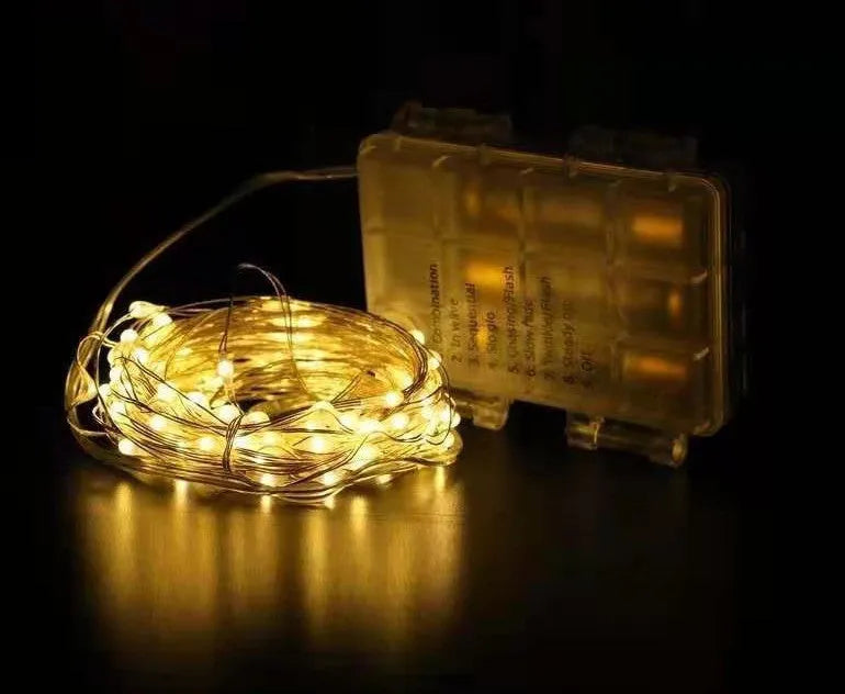 Copper wire battery-operated string lights wrapped around branch with multiple LED colours illuminated