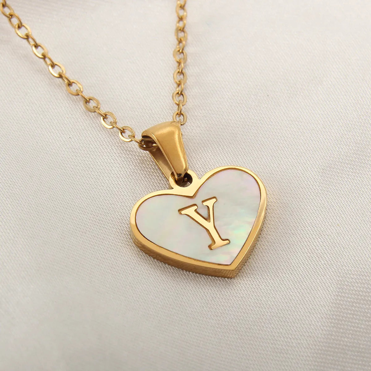 Gold heart necklace with white shell detail and personalised initial letter on adjustable chain