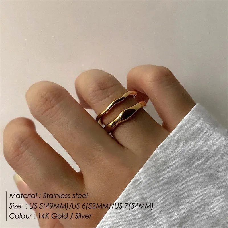 Women's stainless steel ring with wavy geometric design, 18K gold plated, in golden colour, on finger