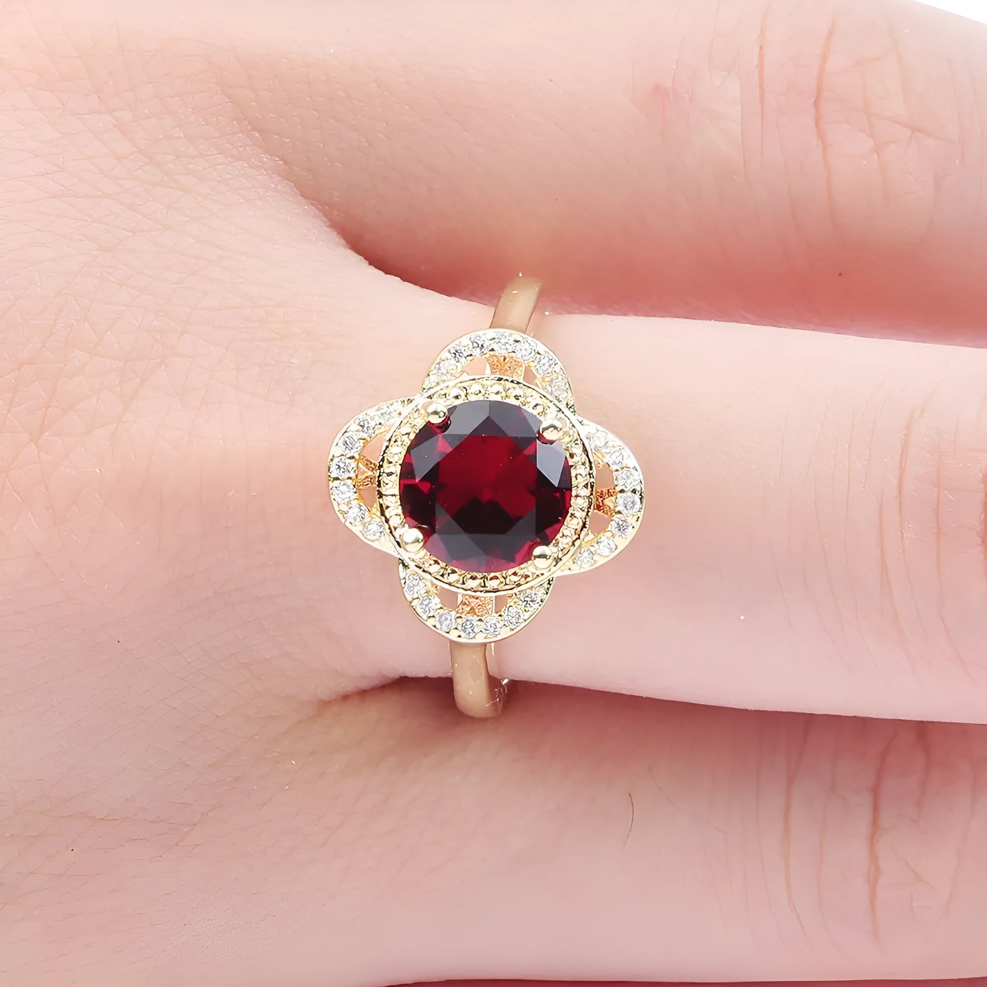 Copper ring with fruit shape and inlaid zircon details on a finger.