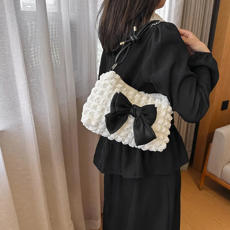Women's black canvas crossbody handbag with single shoulder strap and outer sandwich pocket.