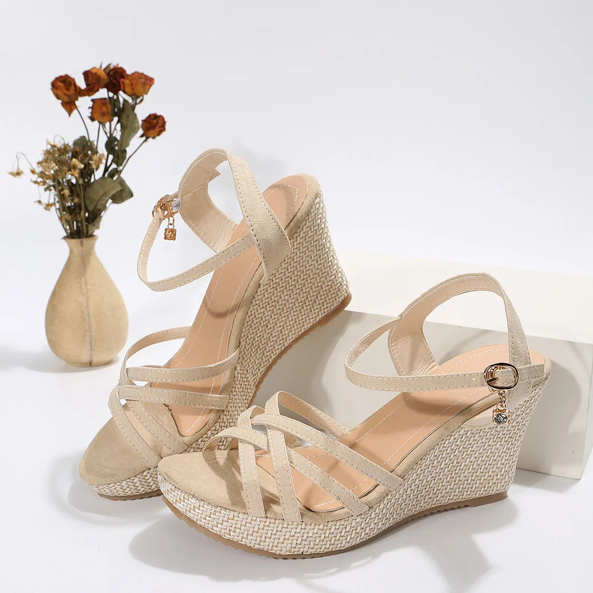Women's beige cloth wedge sandals with a fish mouth toe design on a plain background.