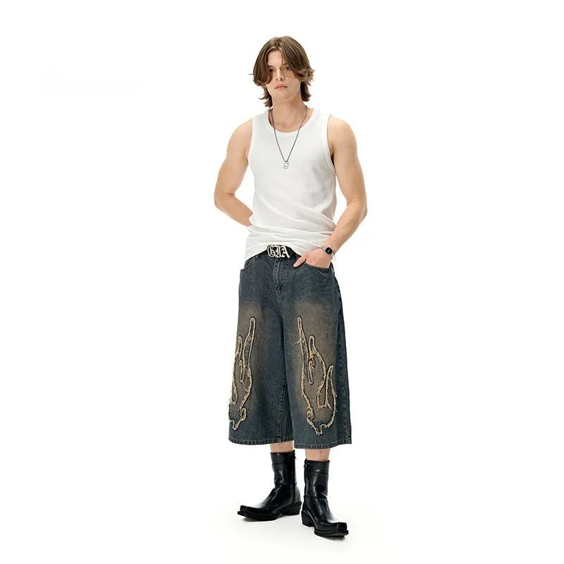 Men's black denim shorts with flame embroidery patch on leg, cropped straight cut style