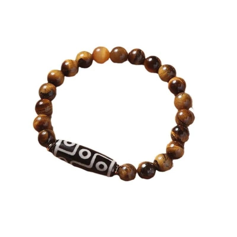 Tigereye Dzi bead single circle Buddha rosary bracelet on a wrist.