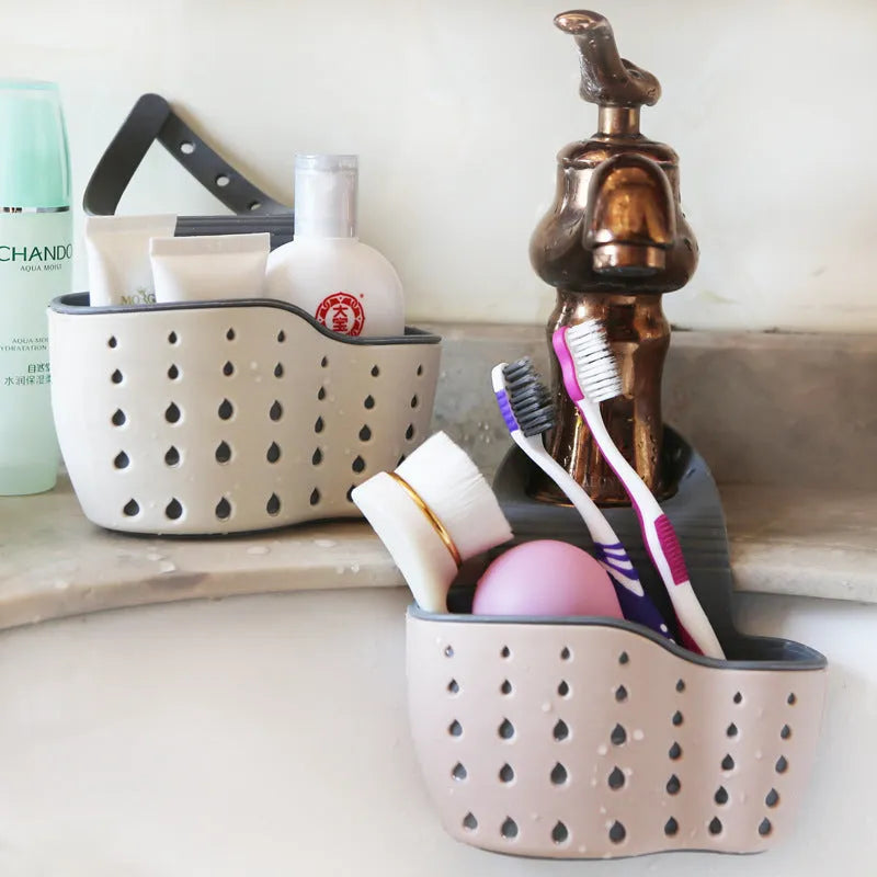 Set of three plastic kitchen sink storage racks in light blue, light pink, and beige on a countertop