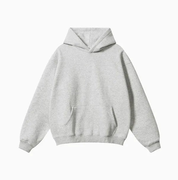 Man wearing a loose-fit grey cotton terry hooded sweater with drop-shoulder sleeves.