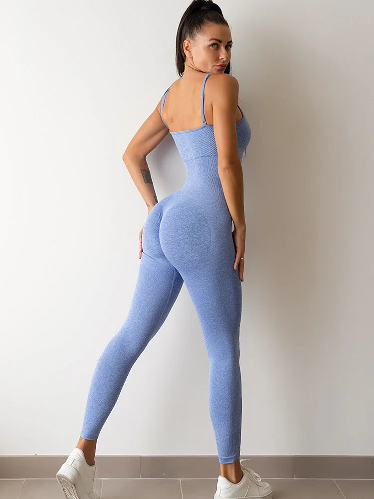 Woman wearing a black sleeveless unitard jumpsuit with spaghetti straps, showcasing the form-fitting tummy control design.