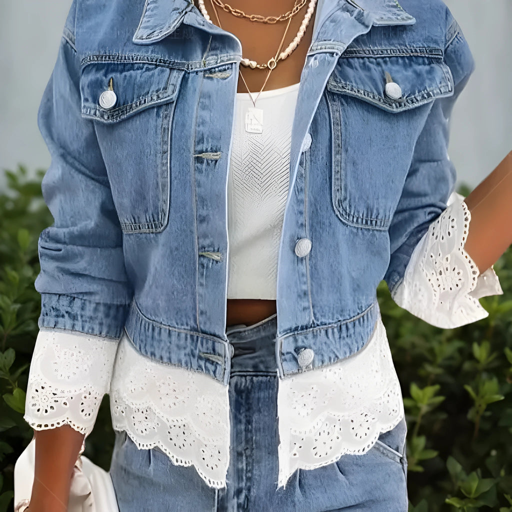 Blue denim jacket for women with lace stitching on the sleeves and front, shown on a hanger.
