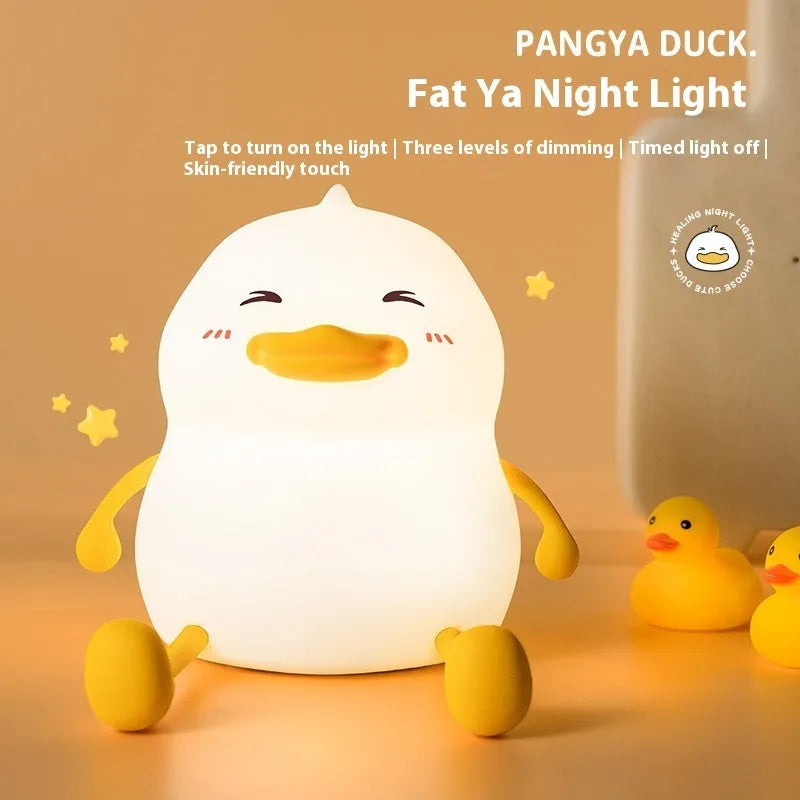 Chubby rechargeable silicone pat night lamp on desk holding a mobile phone