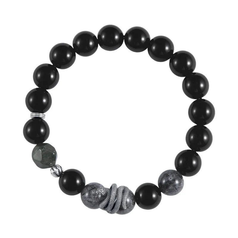 Men's obsidian black snake bracelet made of sterling silver with retro zodiac styling on a wrist.