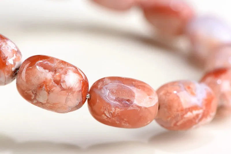 Natural cherry blossom agate barrel bead bracelet with 10mm by 14mm geometry design and ruyi element