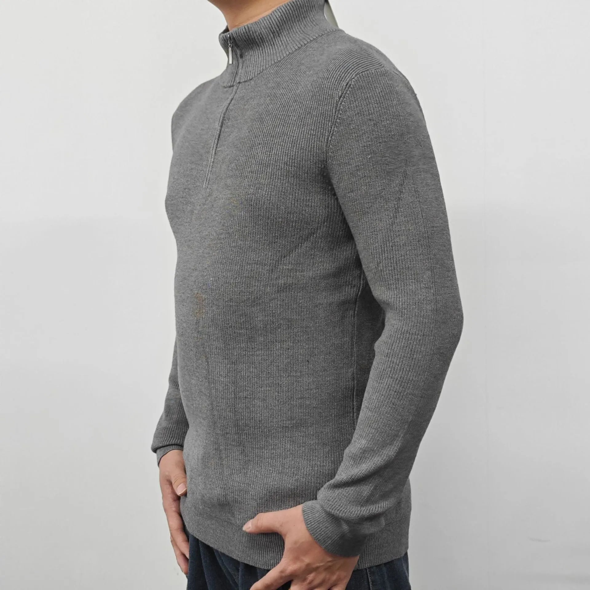 Man wearing a gray zip-front half-turtleneck long sleeve cotton blend sweater.