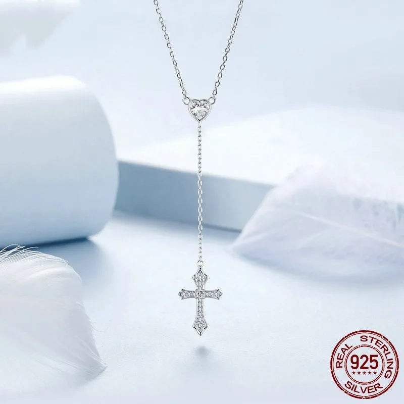 Close-up of a delicate silver love cross pendant on a thin O-ring chain, designed for V-neck wear.