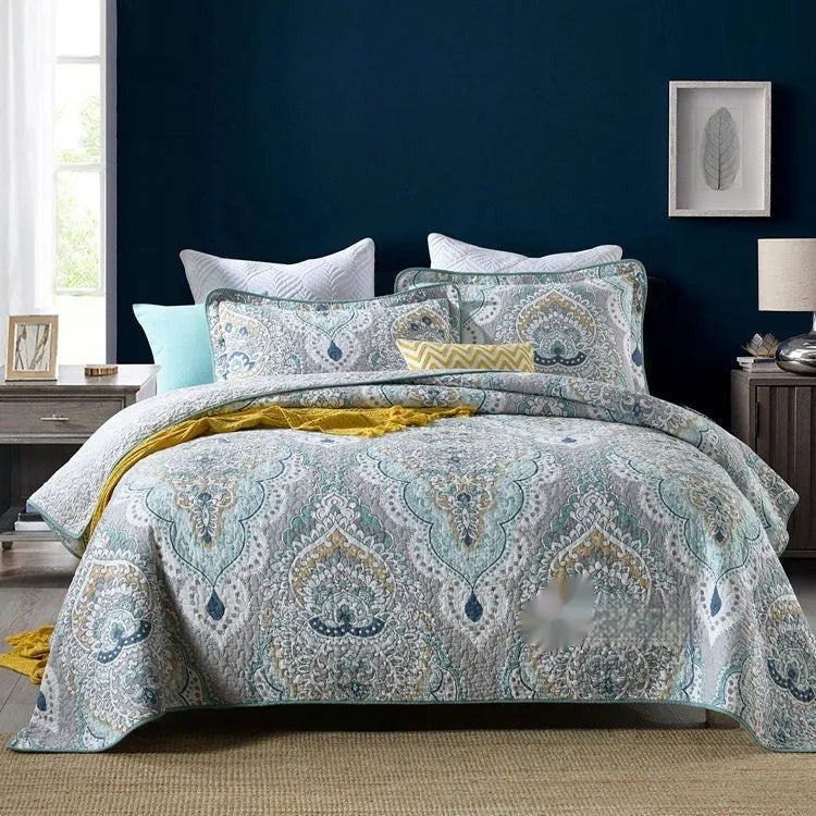 Quilted pure cotton bed cover set with printed pattern on a bed, includes two matching pillowcases.
