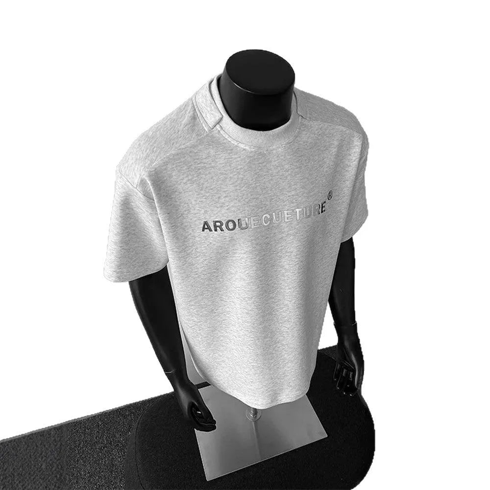 Men's loose fit cotton t-shirt with short sleeves and a printed letter design in light grey.