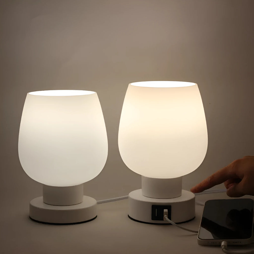 Nordic touch glass desk lamp with three colour settings and USB port on bedside table