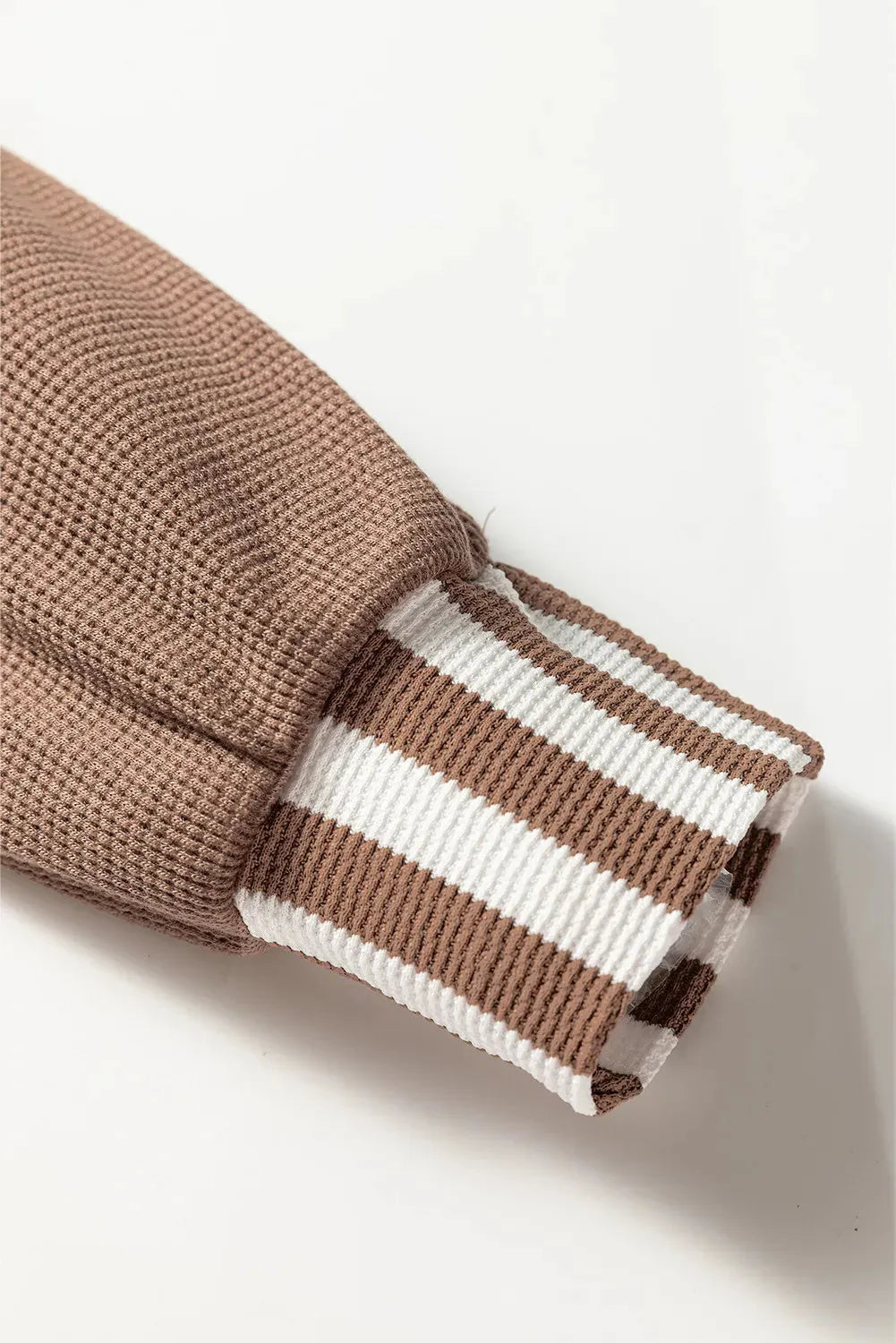 Straw yellow hoodie with waffle texture fabric, striped patchwork design, and button neck closure.
