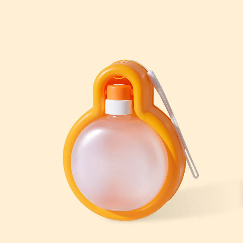 Green and orange portable dog water bottle with pull-out drinking bowl, shown next to a backpack for scale.