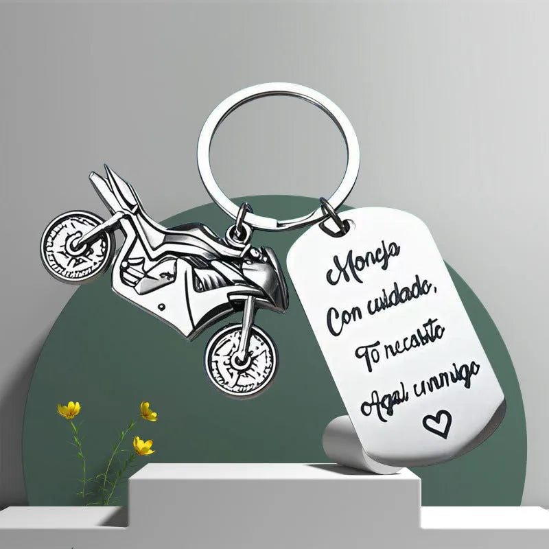 Stainless steel key ring with detailed motorcycle design on metal surface