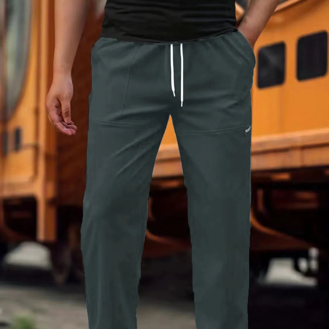 Men's polyester trousers for spring and autumn in light grey, shown flat.