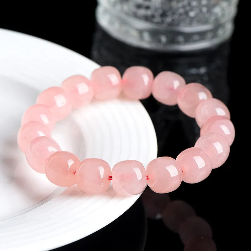 Pink crystal barrel bead stretch bracelet with 8-10mm polished beads on a wrist.