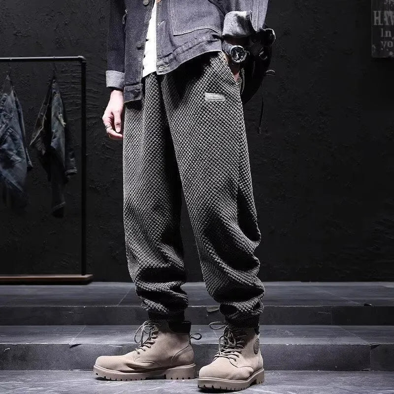 Men's grey ankle-tied straight leg sweatpants with elastic waist on a white background.