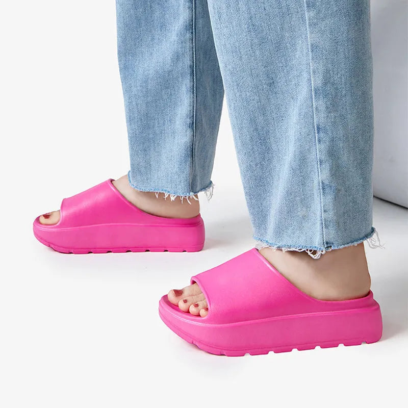 Women's beige thick soled EVA beach slippers with fish mouth design on a wooden floor
